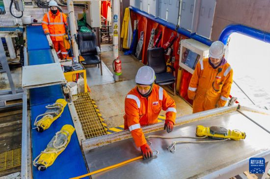 2月10日，在阿塞拜疆巴库船厂码头，中方技术人员（右）在节点船内为阿方工作人员（中）提供指导。新华社记者 陈俊锋 摄