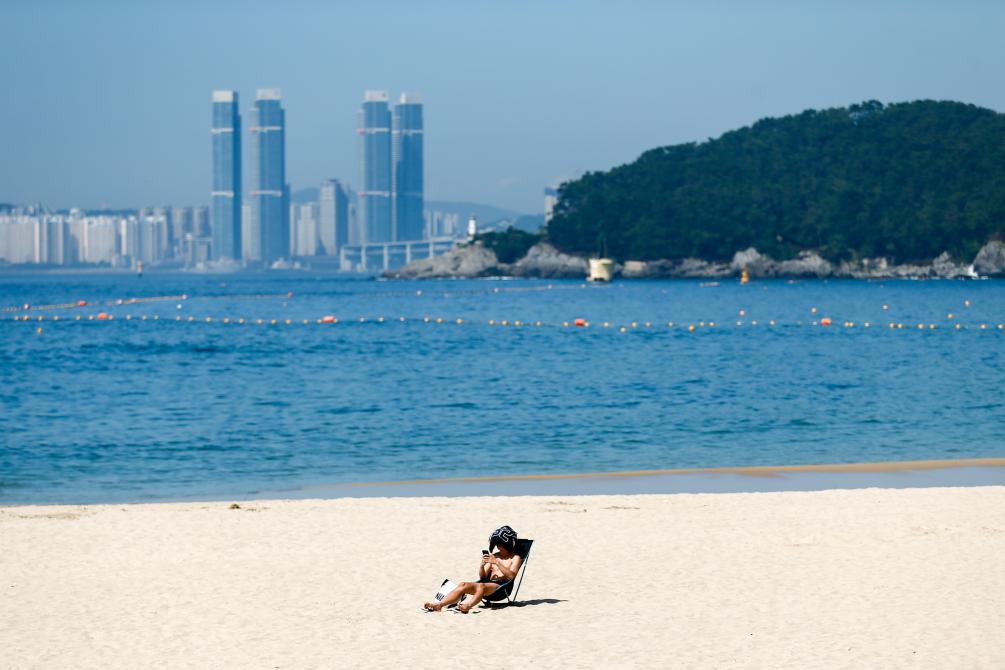 2023年8月3日,市民在韩国釜山的沙滩晒日光浴。新华社记者王益亮摄