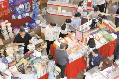 昨天,上海书展主会场上海展览中心,参展商加紧布置展台摆放图书。 记者 赖鑫琳 摄